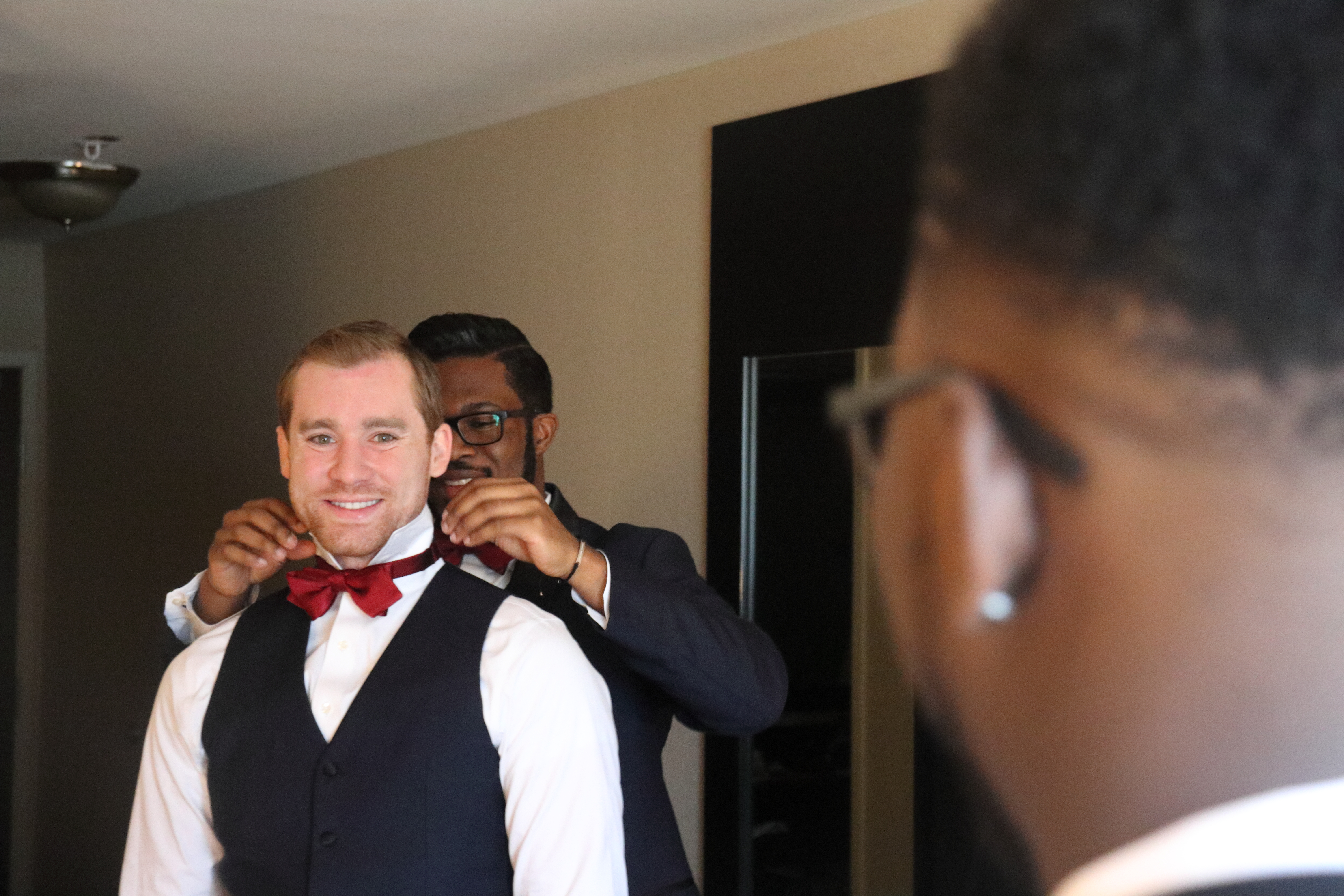 Groom getting ready indoors before a wedding ceremony.